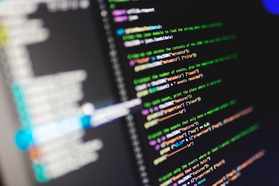 A close-up photograph of a computer screen displaying lines of code in various colors, including orange, yellow, purple, green, and pink, on a dark background. The code appears to be part of a program